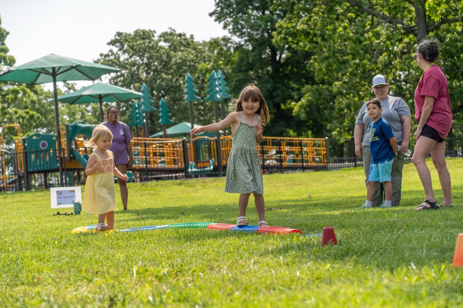 Families spending time together near the playground at a community event.